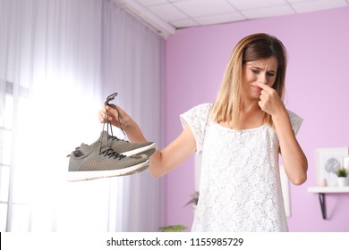 Woman Feeling Bad Smell From Shoes At Home. Air Freshener