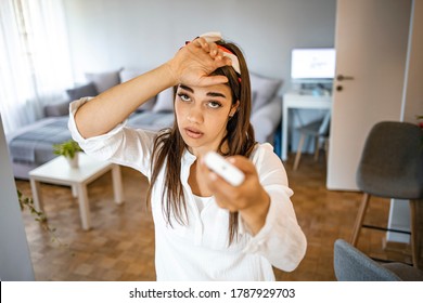 Woman Feeling Bad For Summer Heat Haze.Millennial Woman At Home Exhausted By Hot Weather Closed Eyes Feels Unwell Dying Of Heat Holding In Hand Remote Control Using It For Reducing Too Hot Temperature