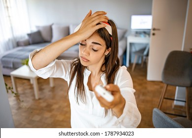 Woman Feeling Bad For Summer Heat Haze.Millennial Woman At Home Exhausted By Hot Weather Closed Eyes Feels Unwell Dying Of Heat Holding In Hand Remote Control Using It For Reducing Too Hot Temperature