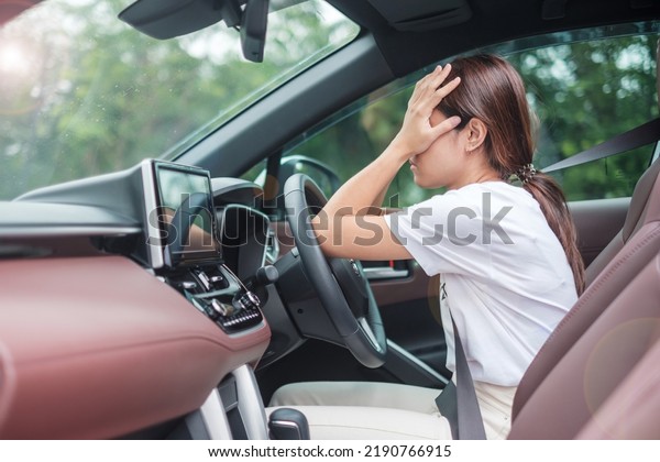 woman feeling\
stress and angry during drive car long time. Asian girl tired and\
fatigue having headache stop after driving car in traffic jam.\
Sleepy, stretching and drunk\
concept