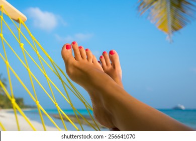 Woman Feet In Hammock On The Beach