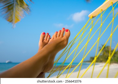 Woman Feet In Hammock On The Beach