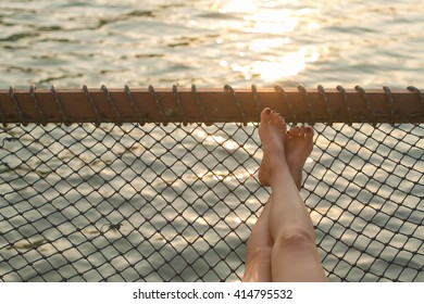 Woman Feet In Hammock On The Beach