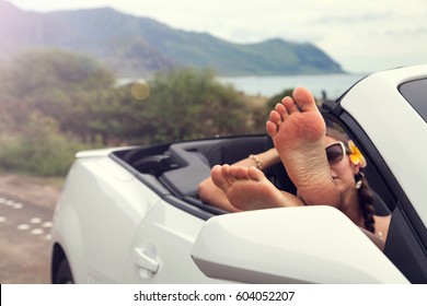 Woman with feet up in luxury convertible, relaxing after walking. Hawaii, USA. - Powered by Shutterstock