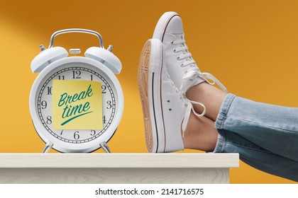 Woman With Feet Up On A Desk And Alarm Clock With Sticky Note, It's Break Time