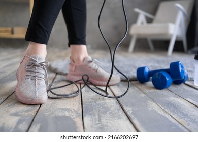 Woman Feet On The Floor After Exercising With Dumbbell And Jump Rope At Home. Concept Of Healthy And Sport