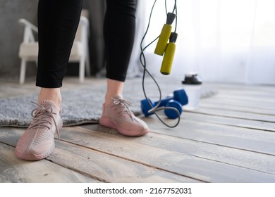 Woman Feet On The Floor After Exercising With Dumbbell And Jump Rope At Home. Healthy And Sport Concept