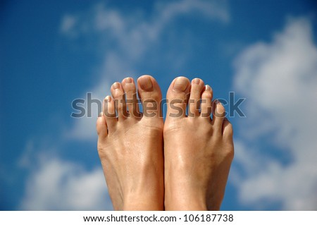 Woman feet on the sky background