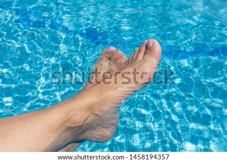 woman feet on the swimming pool