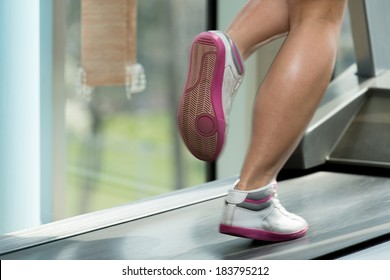 Woman Feet On Treadmill - Close-Up Of Female Legs Running On Treadmill - Blurred Motion