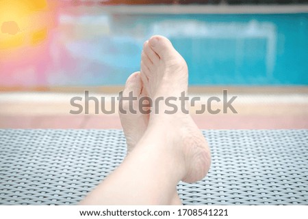 woman feet resting relaxing beside swimming pool. leisure vacation lifestyle