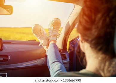 Woman Feet In Sneakers On A Car Dashboard. Roadtrip And Freedom Travel Concept