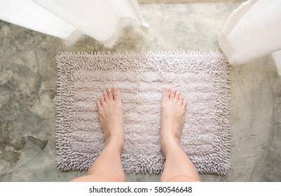 Woman Feet Standing On Old White Or Grey Carpet With Her Bare Feet In Bathroom.