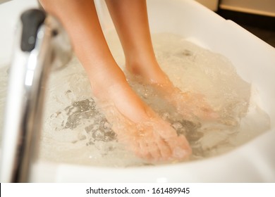 Woman feet taking a relaxing bath in a spa.