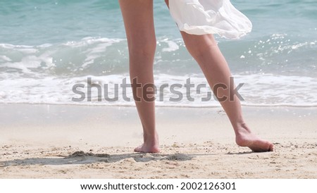 Woman feet walking on the beach 