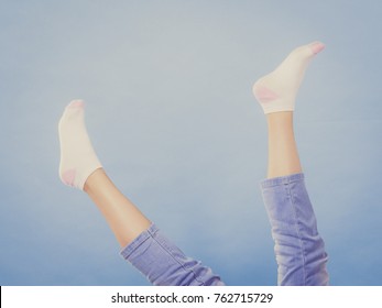 Woman Feet Wearing Clean White Socks And Jeans Having Fun. Studio Shot On Blue Background.