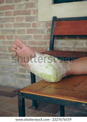 woman feet wrapped in cabbage leaves compress for anti inflammatory effect. Lower body part inflammation. Natural home made italian antique remedies concept.
