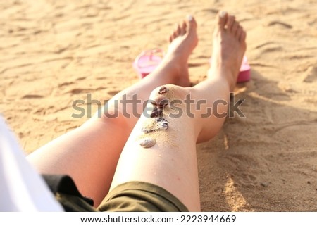 Woman feets on the beach.