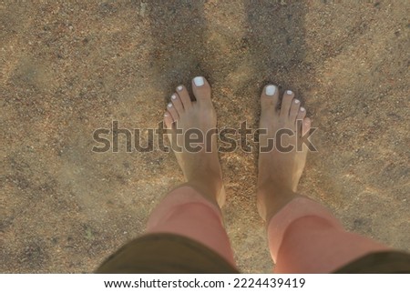 Woman feets on the beach.
