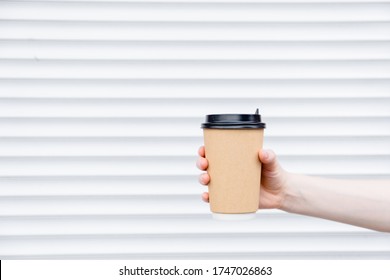 Woman female hand with coffee cup paper latte. Cup in a holder, coffee cup to go takeaway.Top horizontal view