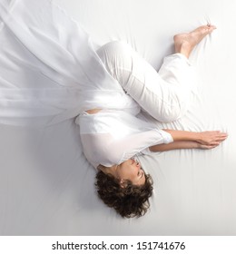 Woman In Fetal Position On White Background