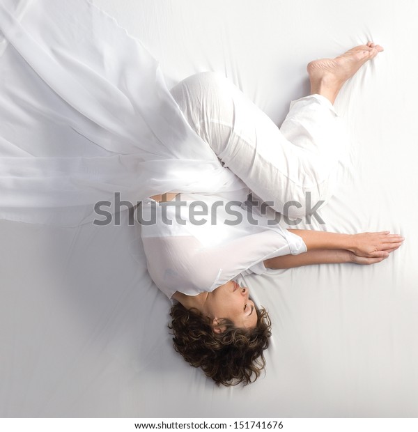 Woman in fetal\
position on white\
background