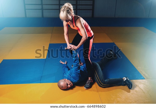 woman-fights-man-selfdefense-technique-600w-664898602.jpg