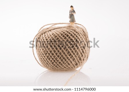 Woman figure at the top a linen spool of thread on a white background