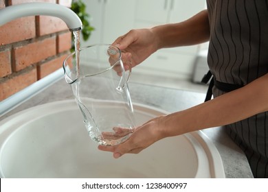 Woman Filling Glass Pitcher With Water, Closeup