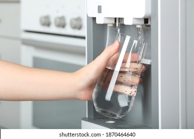 Woman filling glass with water cooler indoors, closeup. Refreshing drink - Shutterstock ID 1870464640