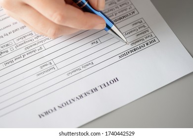 Woman filling hotel reservation form putting first name. Reception desk. Hotel service, registration. Close up. Selective focus. - Shutterstock ID 1740442529