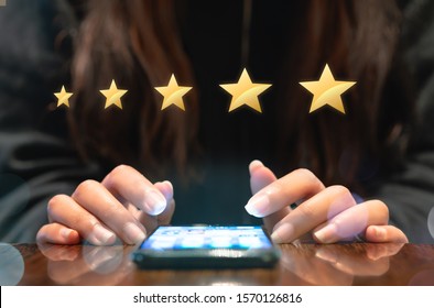 Woman filling out 5 star gold customer service feedback survey on electronic mobile device after online shopping experience - Business satisfaction ratings, retention and quality of service concepts