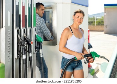 Woman Filling Up Tank Of Her Car With Gasoline In Gas Station