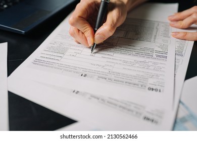 Woman filling US tax form 1040. tax form us business income office hand fill concept. Closeup
