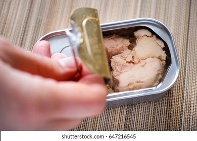 Woman Fingers Opening Tin Can With Cod Liver. 