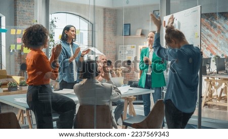 Woman Finishing a Presentation in a Meeting Room at Office With Multiethnic Team. She is Presenting Company Growth Data and Marketing Strategy. Colleagues Clapping, Cheering, Celebrating her Success.