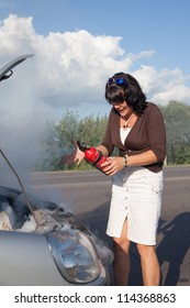 Woman With Fire Extinguisher Near Smoking Car