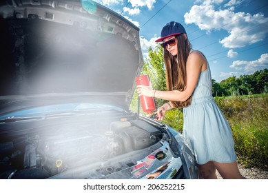 Woman With Fire Extinguisher Near Smoking Car