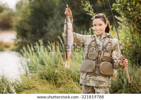 woman Fisherman on the autumn forest background.