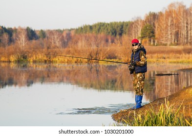 Woman  Fishing  In The Pond In The Fall At Sunset