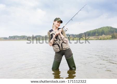 woman fishing in pond in spring