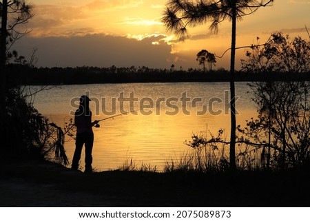 Woman fishing at sunset on lake in Everglades National Park in Florida.