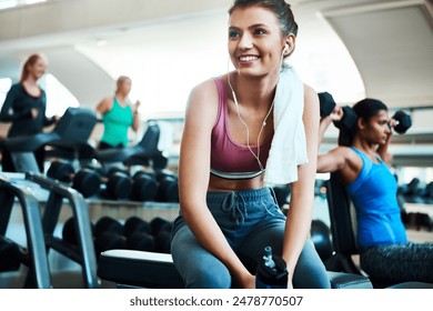 Woman, fitness and earphones with towel, break and excited for results in training or gym. Female person, happy and positive for wellness, health or exercise in rest, workout for strong muscle - Powered by Shutterstock