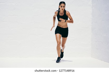 Woman In Fitness Wear Running. Female Athlete Doing Workout.