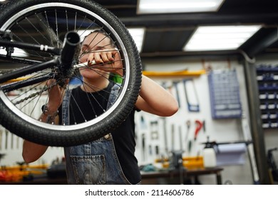 Woman fixing bicycle wheel with wrench - Shutterstock ID 2114606786