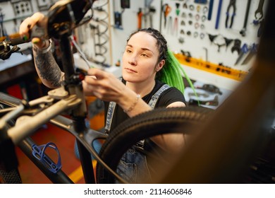 Woman Fixing Bike Seat In Repair Shop