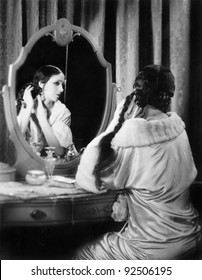 Woman Fixing Her Long Hair At Her Vanity Table