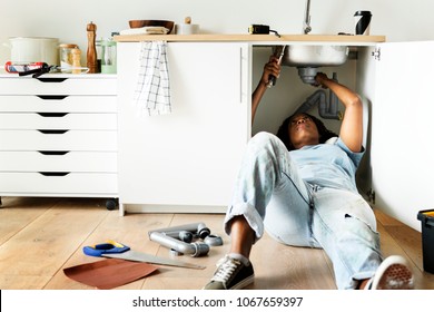 Woman Fixing Kitchen Sink