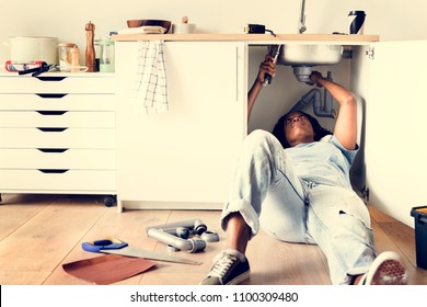 Woman Fixing Kitchen Sink