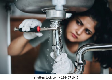 Woman Fixing A Kitchen Sink